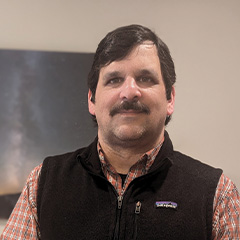 A man with a mustache in a vest.