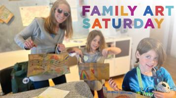 A family displaying the art they just made in a free community workshop