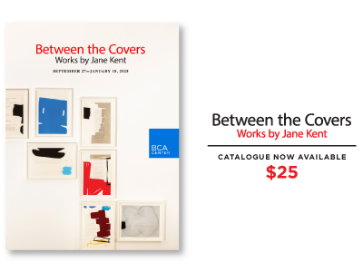 A photo of the artist catalog, "Between the Covers", with text next to it describing how much the book is.