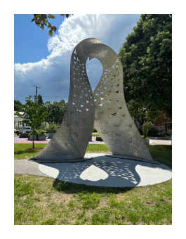 A steel sculpture of two birds embracing.