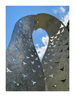 A close up of a steel sculpture of two birds embracing.