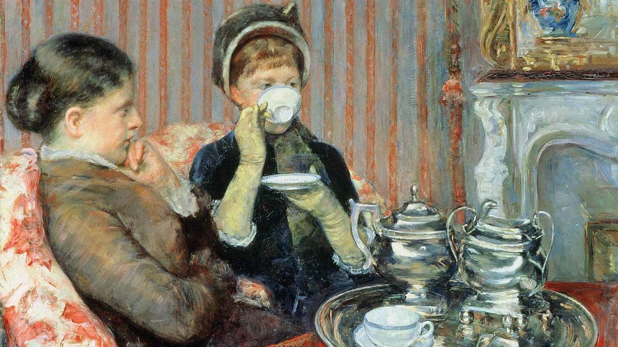 A painting of two light skinned nineteenth century women sitting on a red and white floral settee drinking tea. One woman wear a bonnet and sips from a white tea cup, while the other woman sits bside her. The silver tea service sits on a tray in the foreground. In the background an intricate white marble mantle piece is visible set against grey and pink striped wall paper.