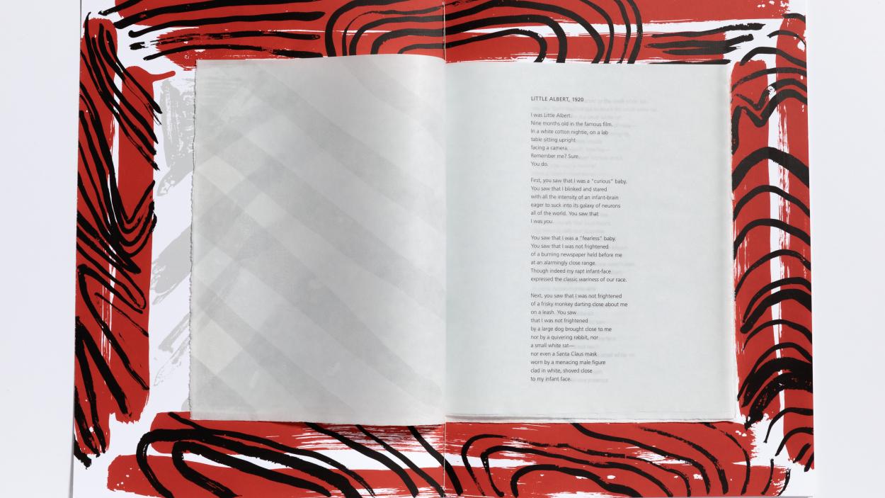 An image of an open book surrounded by an elegantly stylized red border.